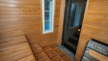 Un intérieur en bois avec un banc, une porte et une cheminée.