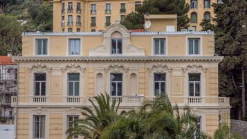 Un edificio de varios pisos con arquitectura clásica, que presenta balcones y detalles ornamentales.