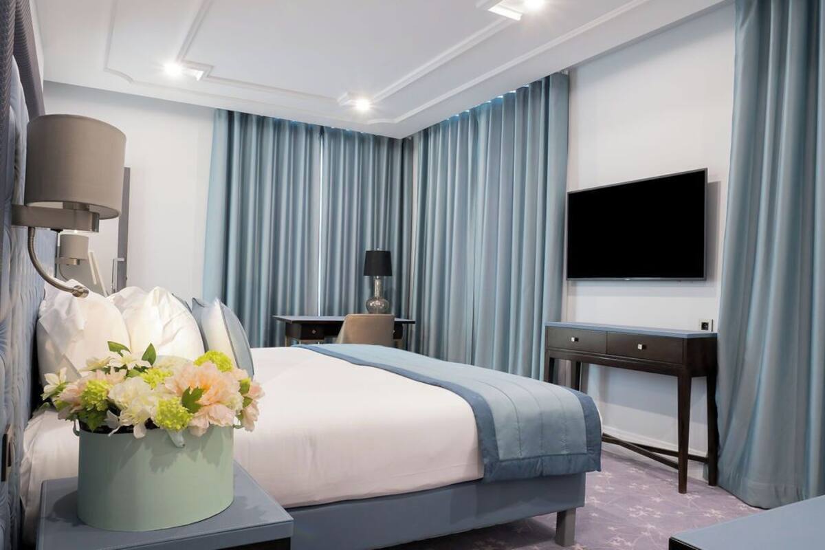 Une chambre d’hôtel moderne équipée d’un grand lit, d’un téléviseur à écran plat, d’un bureau et d’une chaise.
