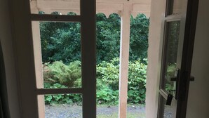 Uma entrada para uma área de jardim com chão de azulejos e um tapete.