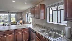 A kitchen with granite countertops, wooden cabinets, a dishwasher, and a double sink. - < 1 Mi to Strip! Golfer's Oasis w/ Pool in Branson (Branson)
