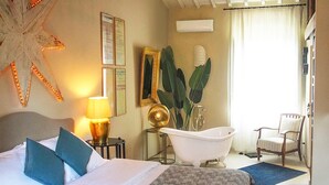 A hotel room with a bed, a starfish decoration, a bathtub, a chair, and a plant. - Agriturismo La Striscia (Arezzo)
