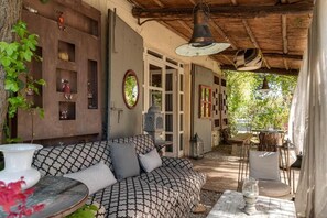 A cozy outdoor seating area with a patterned sofa, a table, and decorative items. - Agriturismo La Striscia (Arezzo)
