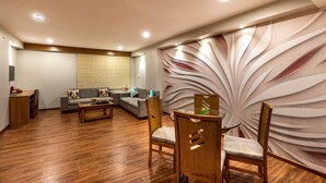 Una sala de estar moderna con un sofá, una mesa de centro y un comedor con sillas y una mesa de vidrio.