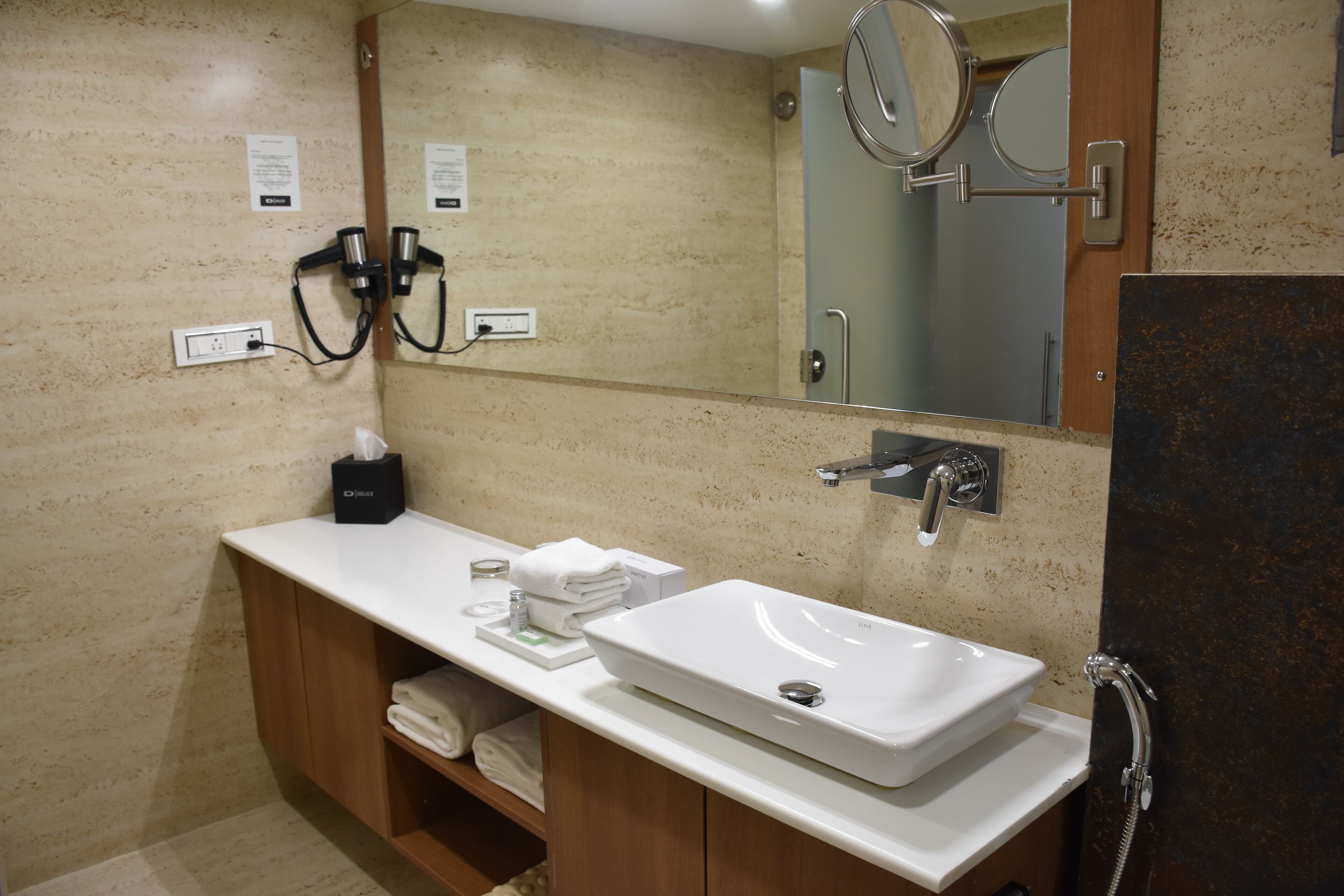 Une salle de bain moderne avec un lavabo blanc, un miroir et un porte-serviettes.