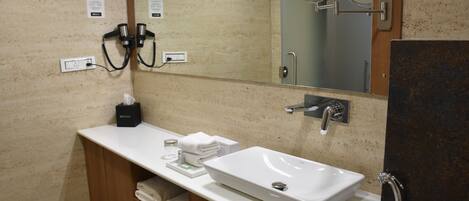 Une salle de bain moderne avec un lavabo blanc, un miroir et un porte-serviettes.