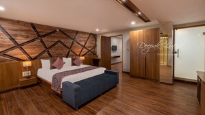 Un dormitorio moderno con una pared de acento de madera, una cama con cabecera azul y una mesita de noche con lámpara.