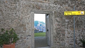 A stone doorway leading to a view of a town with a sign reading "chiesetta di San Rocco". - Luxury San Rocco near BELLAGIO (Lezzeno)
