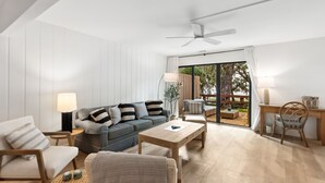A modern living room with a sofa, chairs, a coffee table, and a desk with a lamp. - 2135 Beachwood - Delightful Town-home with calming views in a Relaxed Setting (Fernandina Beach)