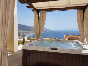 Ein Whirlpool mit Blick auf Meer und Berge.