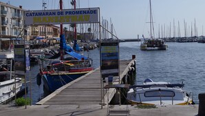 Un puerto deportivo con barcos amarrados, un cartel que dice "Catamaran de Promenade" y un muelle de madera.