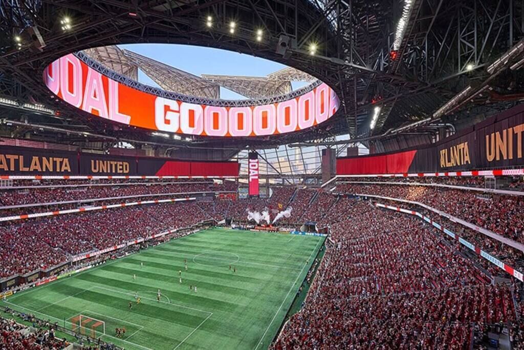 A large stadium with a central field surrounded by a packed audience.