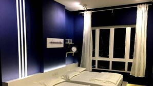 A bedroom with two beds, a nightstand with a clock, a window with curtains, and a wall-mounted light fixture. - Excellent Location Premium Studio @ Palo 101 Ipoh (Kampung Jawa)