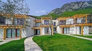 A modern building with multiple balconies and a central courtyard. - lake view apartment quiet location parking and swimming pool in the olive trees. (Gargnano)