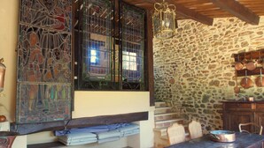 Un'accogliente zona pranzo in stile rustico, con parete in pietra, travi in legno e un tavolo con sedie.