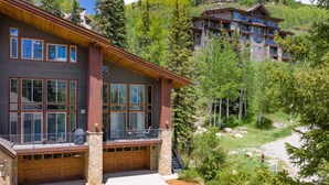 A modern multi-story building with large windows, a covered patio, and a stone foundation. - Ping Pong, Foosball, Pet Friendly, Mountain Living (Durango)