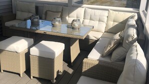 A covered outdoor seating area with wicker furniture, a glass-top table, and cushions. - Walkable Location Cape May Home w Pool, 1st-Fl BR, Near Dining, Market & Beach (West Cape May)