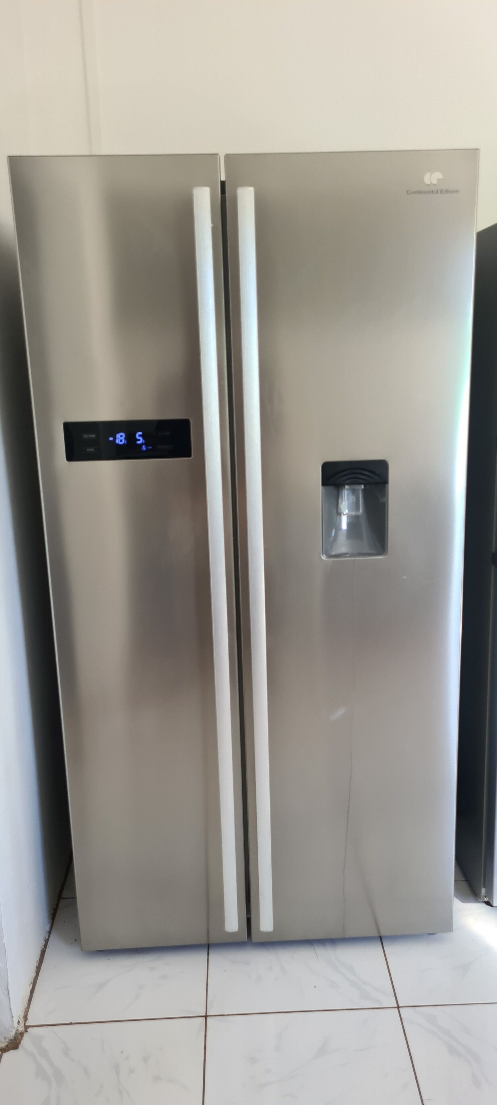 A stainless steel refrigerator with a digital display and a water dispenser.