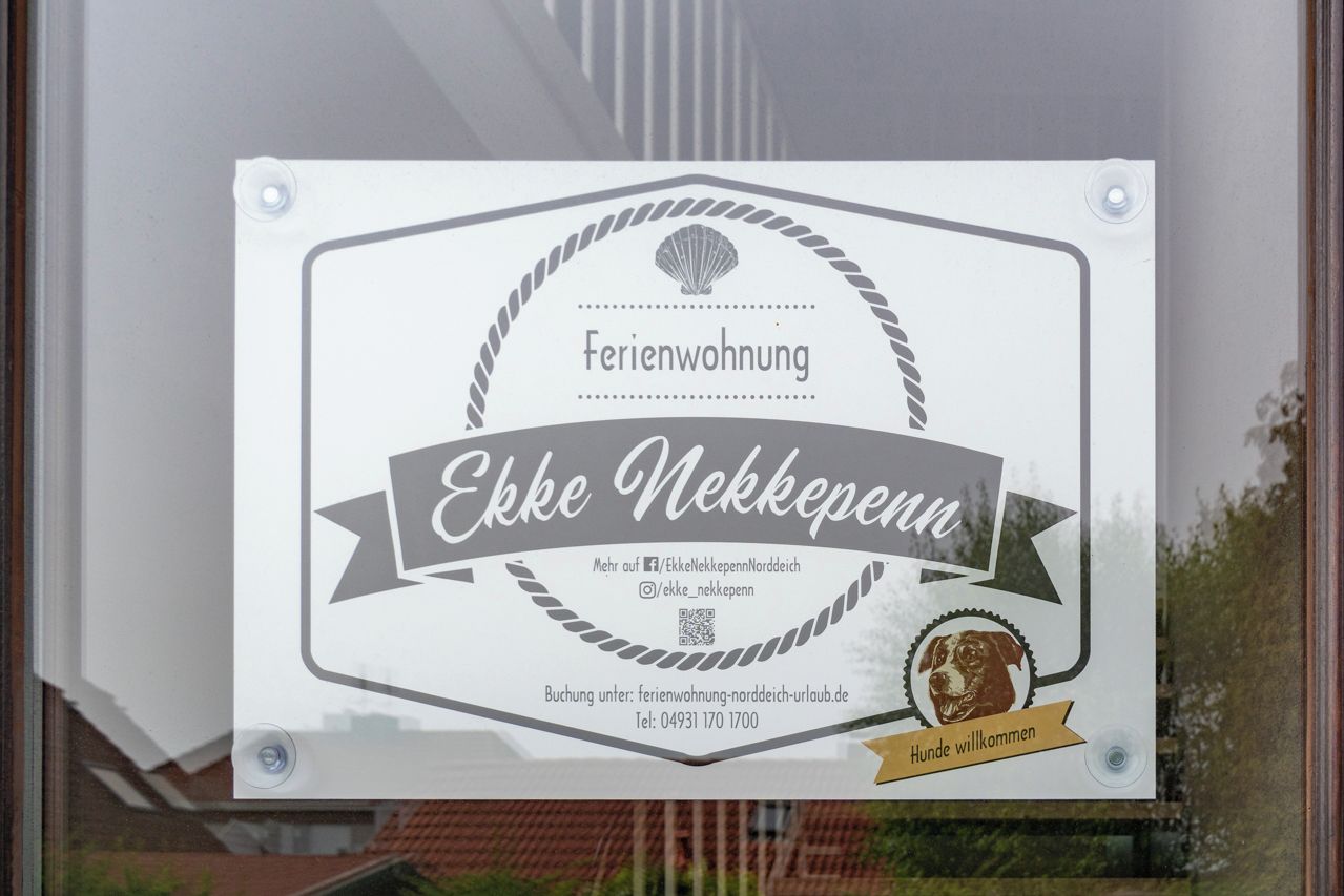 A sign for 'Ekke Nackkeppenn' hotel with contact information and a QR code.
