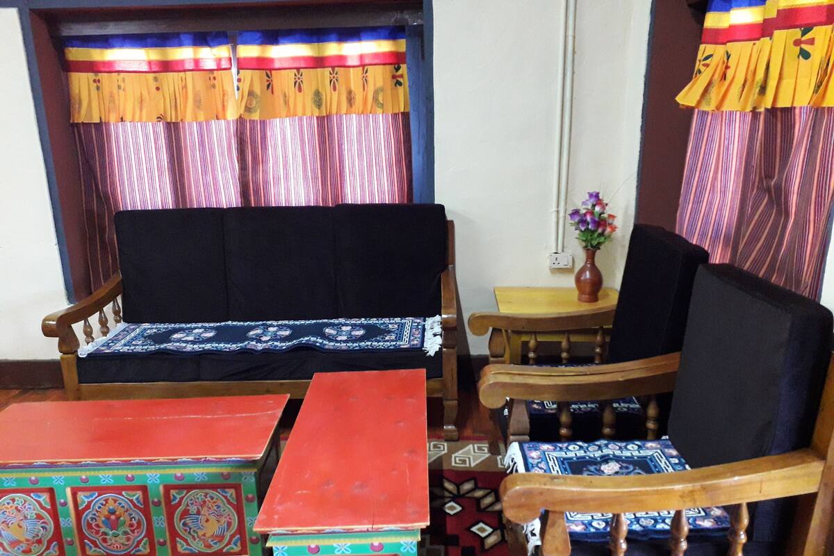 A room with a sofa, a chair, a small table, and a decorative cabinet.