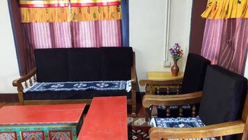 A room with a sofa, a chair, a small table, and a decorative cabinet.