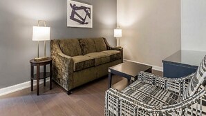 A living room with a sofa, a patterned armchair, a coffee table, and two floor lamps. - The King 583 in Charleston (Charleston)