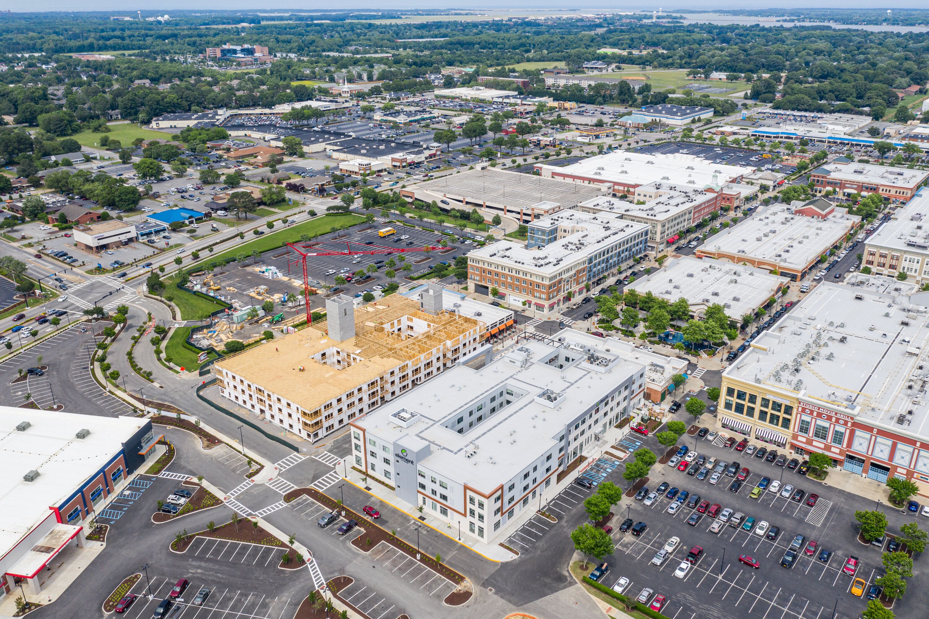 An aerial view of a commercial area with multiple buildings, parking lots, and roads.