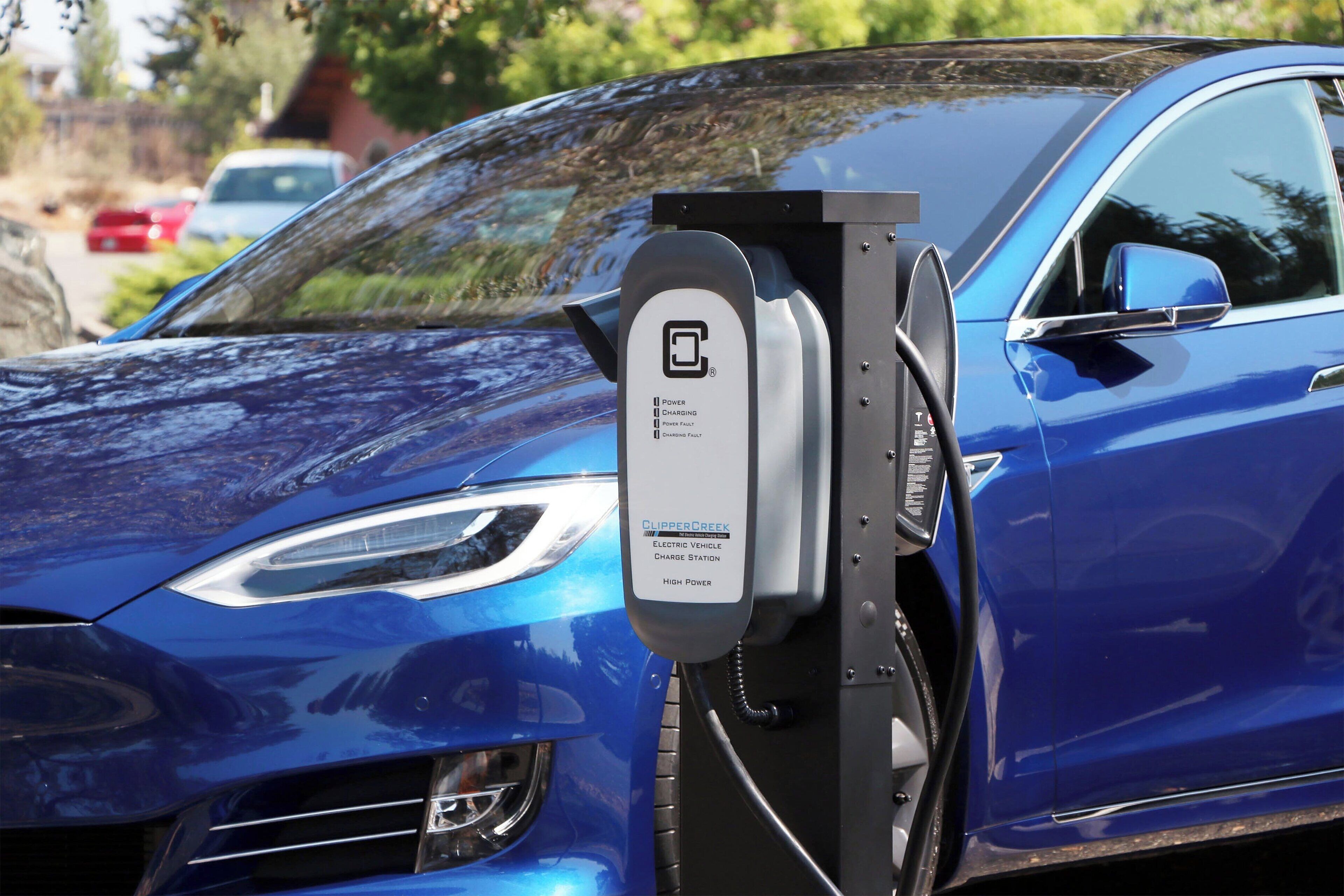 Un véhicule électrique bleu en cours de recharge à une borne.