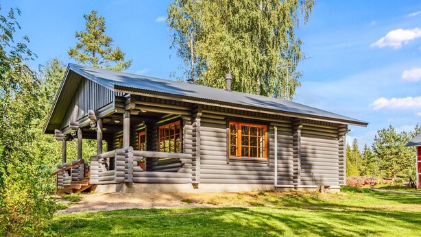 A log cabin with a porch, large windows, and a chimney. - Marttalanmäki by Interhome (Sysmä)