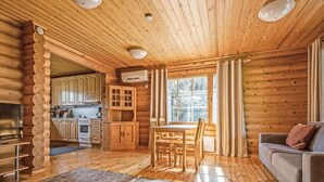 A log cabin interior with a dining area, kitchen, and living room. - Marttalanmäki by Interhome (Sysmä)