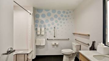 A modern bathroom with a toilet, sink, and shower area.