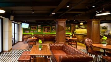 A restaurant interior with leather seating, a bar area, and a television screen.