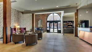 A spacious lobby with a reception desk, seating area, and a large arched doorway leading outside. - SpringHill Suites by Marriott Montgomery Downtown (Montgomery)