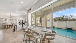 A spacious kitchen with a dining area and a pool. - 1/2 Block From Private Beach, 7 BR, Remodeled, Theater, Discounted Golf Cart (Miramar Beach)