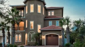 A two-story house with a flat roof, multiple windows, and a garage. - 1/2 Block From Private Beach, 7 BR, Remodeled, Theater, Discounted Golf Cart (Miramar Beach)