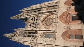 Vista detallada de la fachada de una catedral imponente, con detalles arquitectónicos intrincados y un amplio ventanal circular.
