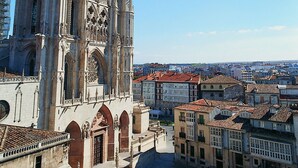 Una catedral con intrincada arquitectura gótica, una amplia plaza abierta y edificios históricos circundantes.