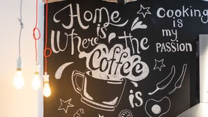 A kitchen with a chalkboard wall that reads "Home is where the coffee is my passion." - Good People Design Hostel (Belgrade)