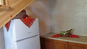 Eine Küche mit einem weißen Kühlschrank, Holzschränken und einer gefliesten Spritzschutzwand.