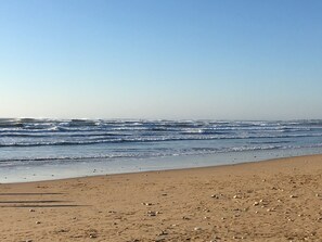 Une plage avec des vagues et un ciel dégagé.
