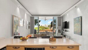 Een moderne keuken met een groot eiland, een eetgedeelte met uitzicht en een plafondventilator.