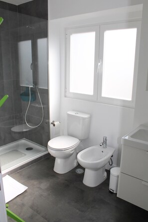 Een douche, een haardroger, een bidet, handdoeken
