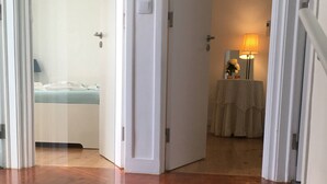Un escalier menant à une chambre à coucher équipée d’un lit et d’une lampe de chevet.