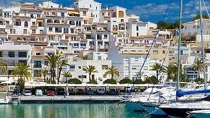 A coastal town with white buildings, a marina with boats, and palm trees. - Traditional family villa, private pool and hillside views, 5 mins to Moraira. (Teulada)