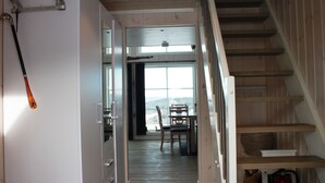A wooden staircase leading to a dining area with a view of the outdoors.