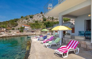 Relax on the beachside with lounge chairs and stunning sea views.