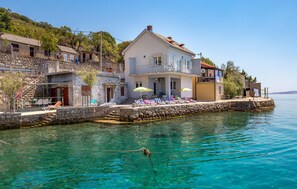 Overlooks a serene body of water with a balcony.