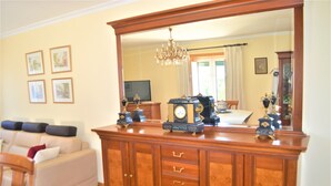 A living room with a large wooden cabinet, a sofa, and a television. - Casa Límia (Ponte de Lima)