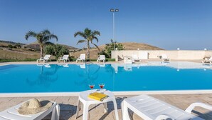 A pool area with lounge chairs, a table with drinks, and a view of the landscape. - Lovely home in Ragusa with outdoor swimming pool (Ragusa)