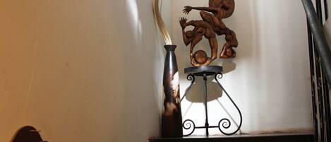 Una escalera con una escultura metálica decorativa en el descansillo.